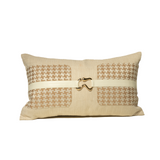 Decorative pillow with a houndstooth pattern and a gold buckle on a white background