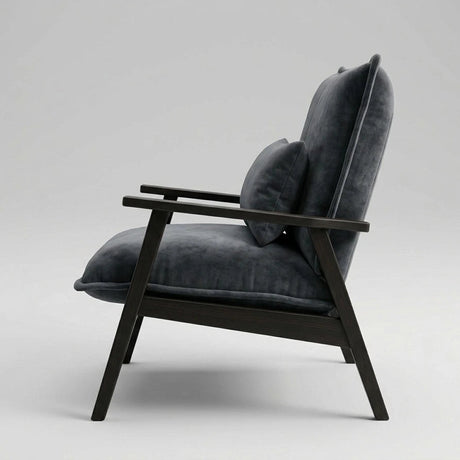 A modern lounge chair with dark charcoal gray velvet cushions and a dark wood frame, shown from a side profile against a light gray studio background.