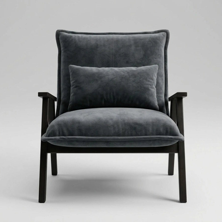 A modern armchair with dark gray velvet upholstery and a matching back cushion, supported by a dark wood frame, shown against a neutral light gray background.