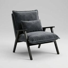 A modern accent chair with dark gray velvet cushions and a black wooden frame, shown against a neutral light gray background.