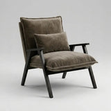 A modern accent chair with plush taupe-brown velvet cushions and a matching back pillow, supported by a dark wood frame, photographed on a seamless light gray studio background.
