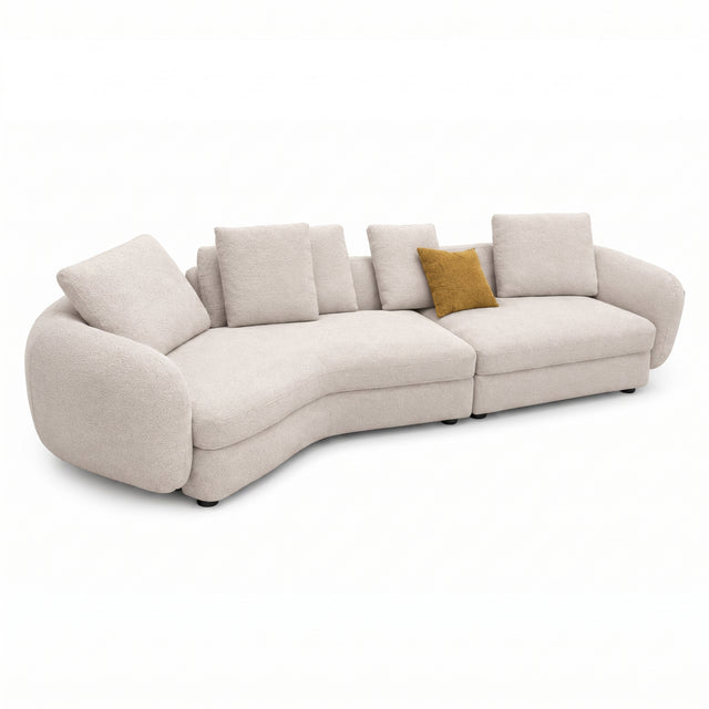 A modern curved upholstered sofa in a light beige textured fabric, featuring multiple matching back cushions and a single mustard yellow accent pillow, shown on a plain white background.