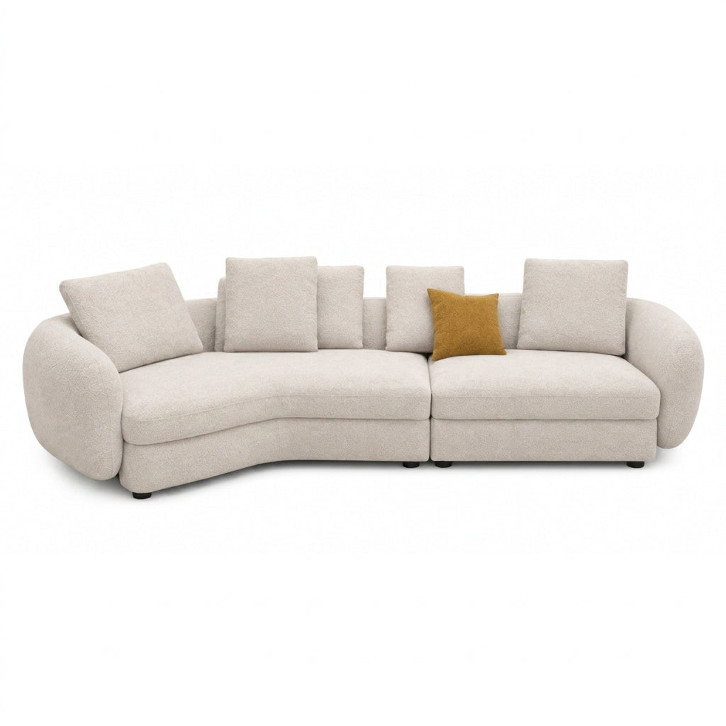 A curved modular upholstered sofa in a light beige fabric, featuring multiple square back cushions and a single mustard yellow accent pillow, shown against a plain white background.