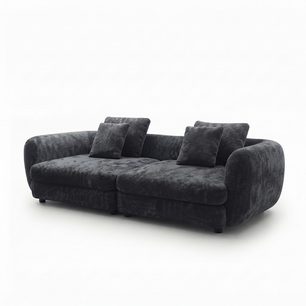 A modern curved three-seater sofa upholstered in dark charcoal gray plush velvet fabric, shown with four matching throw pillows against a plain white background.