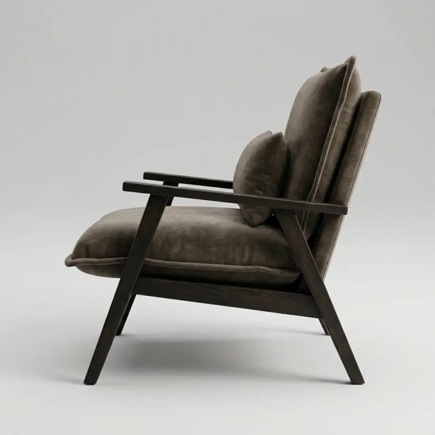 A mid-century modern armchair with dark brown wooden frame and taupe-brown velvet cushions, shown from a side profile against a light gray studio background.