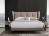 Beige upholstered bed with white bedding in a modern bedroom setting.